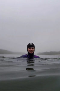 Janine schwimmt im Neoprenanzug durch den Nebel